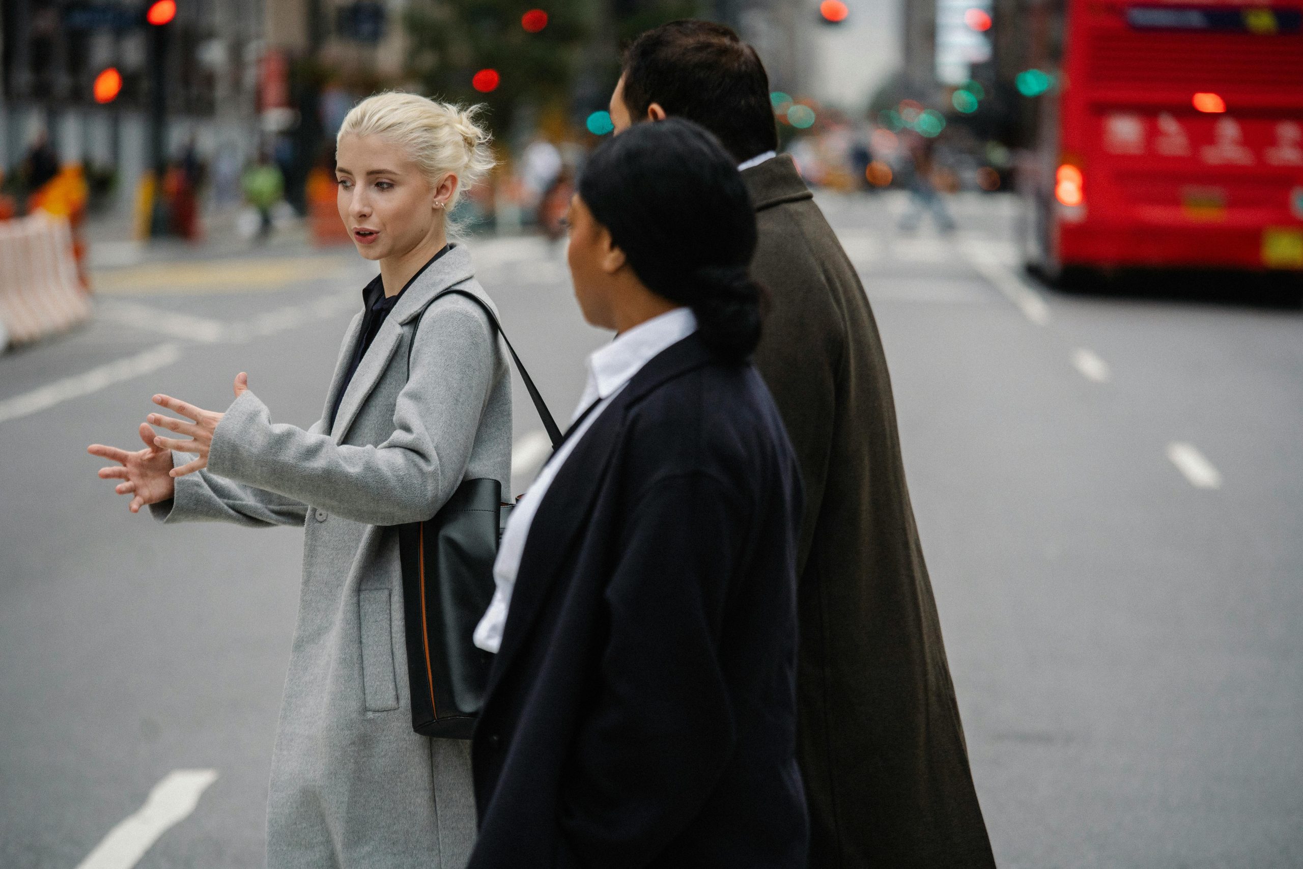 Businesswoman talking to unrecognizable multiethnic partners on urban road